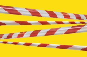 Red and white warning lines of barrier tape prohibit passage